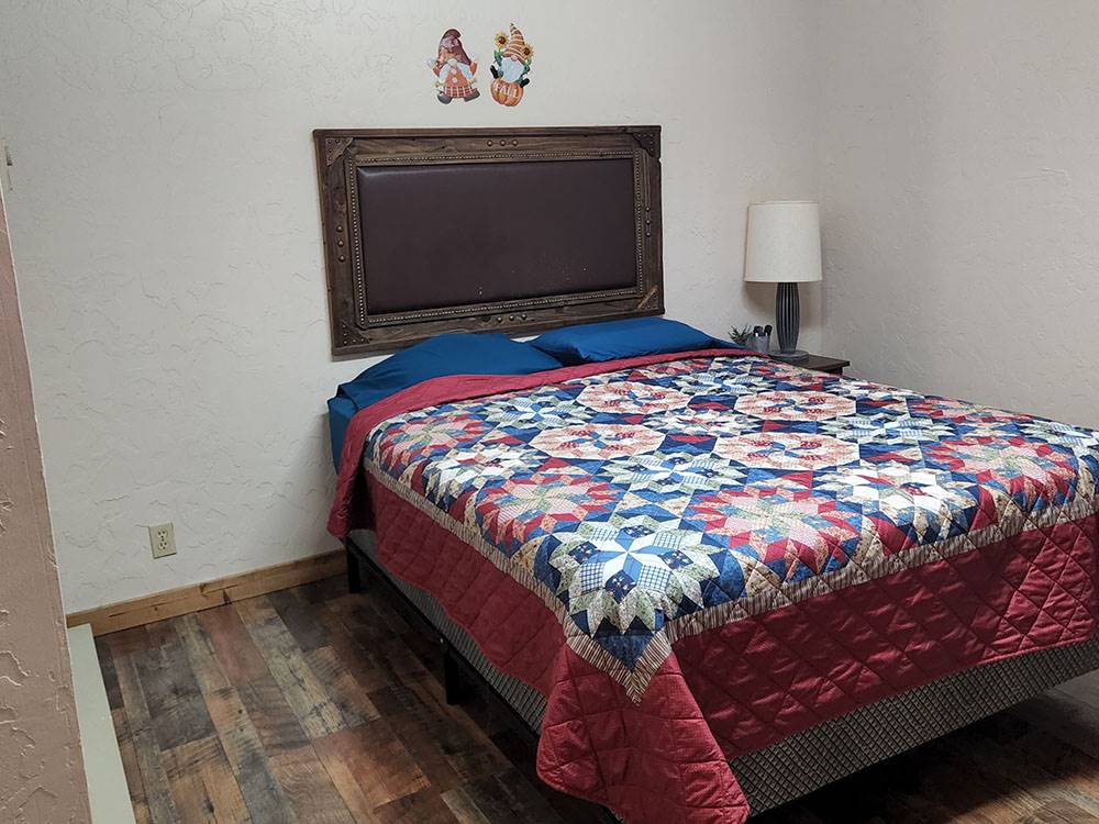 Bed with a quilt at The Bunkhouse Cabins and RV Park