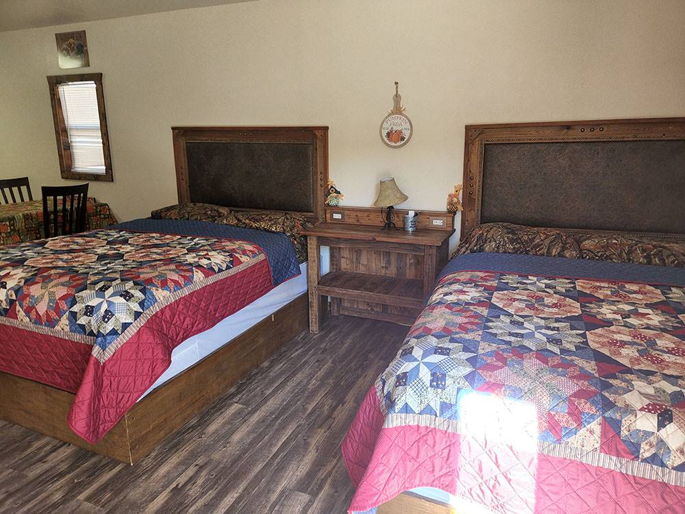 Two beds and a table with chairs at The Bunkhouse Cabins and RV Park