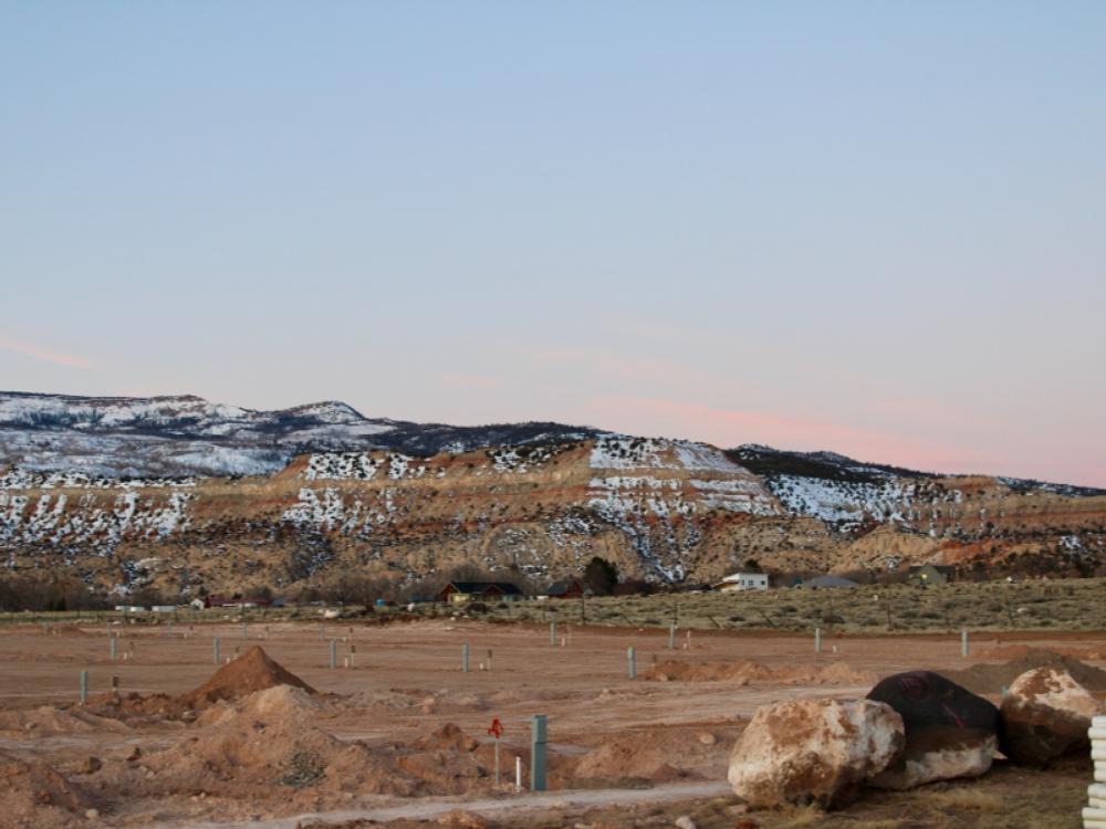 Dirt sites in front of snow topped hills at Capitol Reef RV Park & Glamping