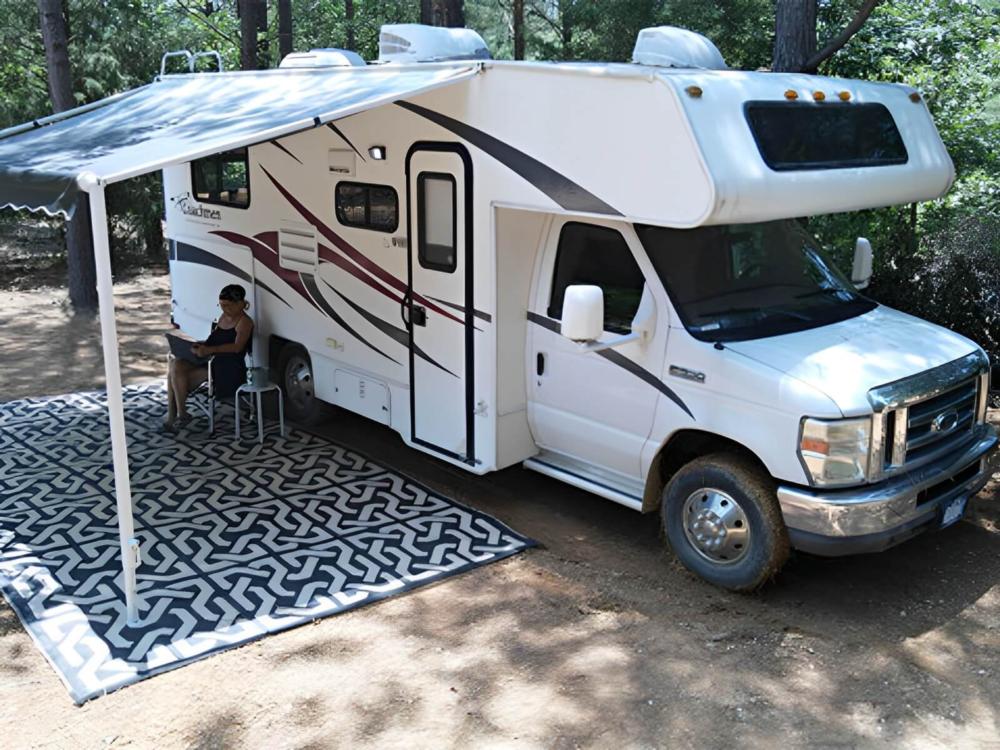 Parked RV with covered patio at site Harmony Ridge RV Park