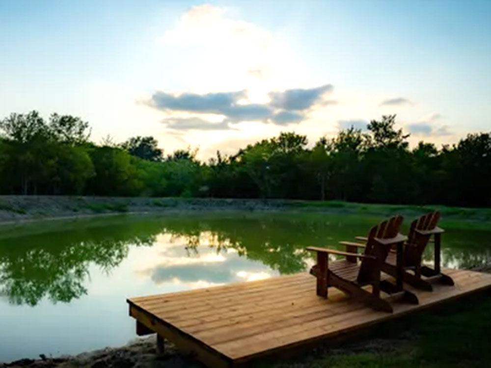 Pond with deck and chairs at SILO CREEK RV RESORT