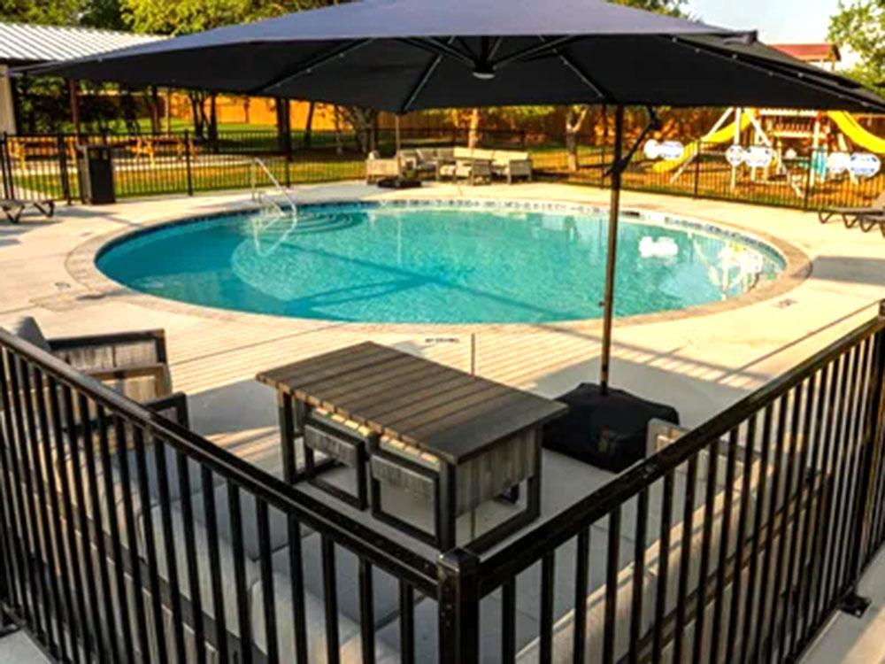 Outdoor pool with playground in the background at SILO CREEK RV RESORT