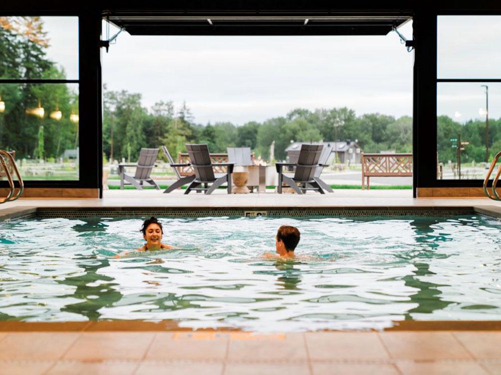 People in the pool and outdoor patio seating at ANGEL OF THE WINDS CASINO RESORT