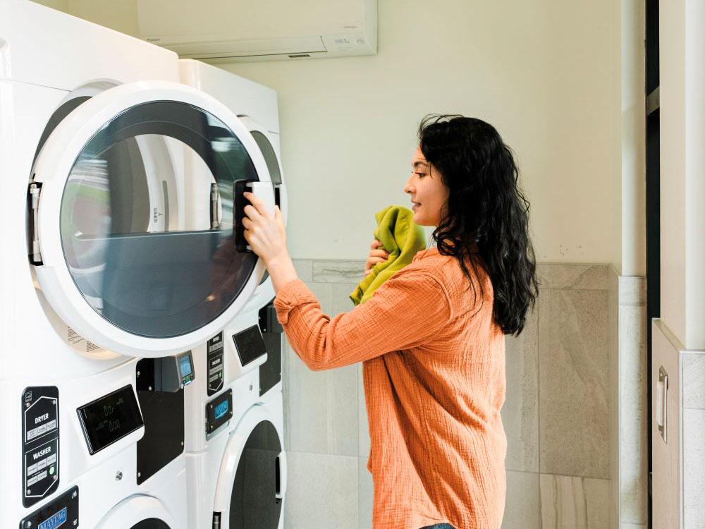 A woman doing laundry in the laundry facility at ANGEL OF THE WINDS CASINO RESORT