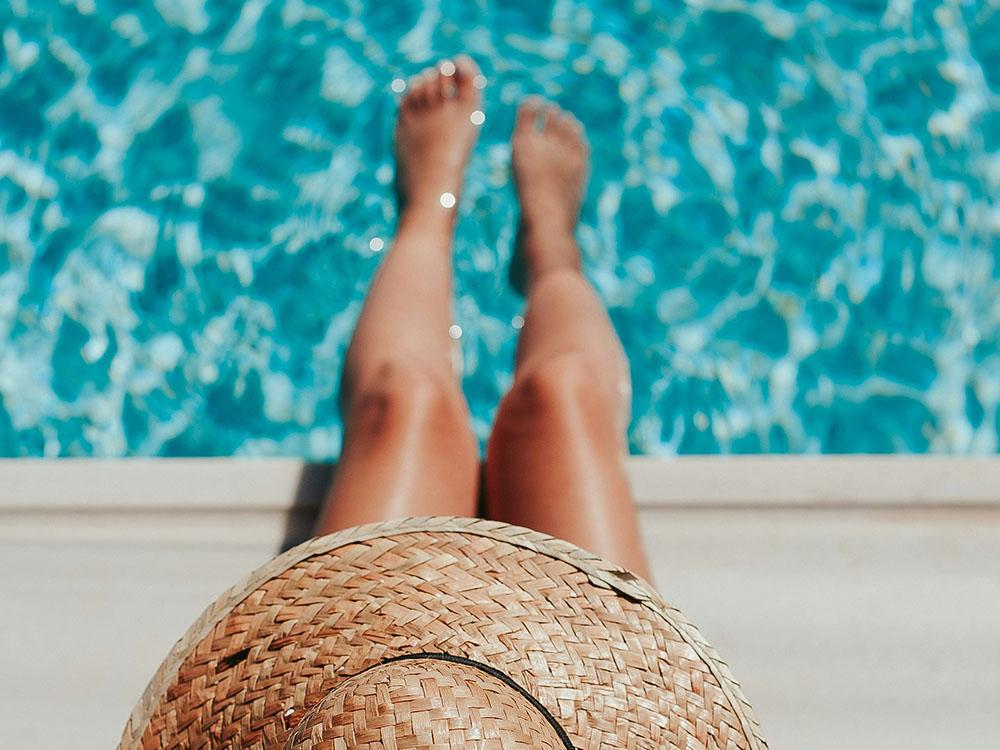 Woman in sun hat by the pool at PARADISE RV PARK