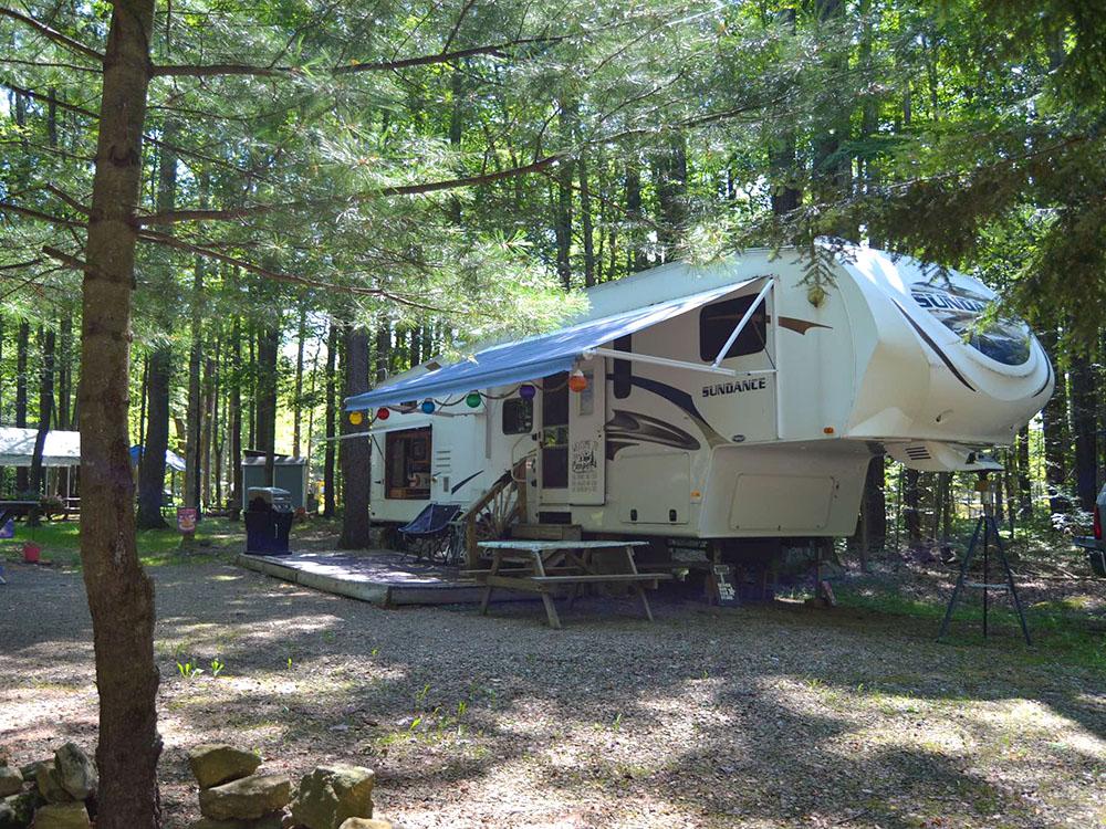 A fifth wheel parked at a shaded site at KINZUA EAST KAMPGROUND