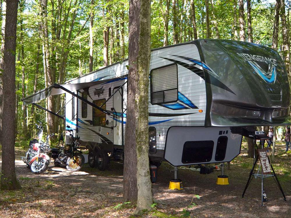 Travel trailer parked at a shaded site at KINZUA EAST KAMPGROUND