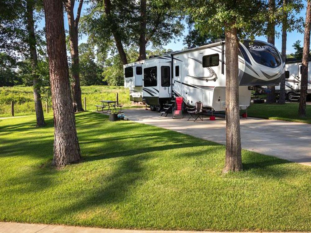 A fifth-wheel with a slide-out at site at WOODLAND CREEK RV PARK