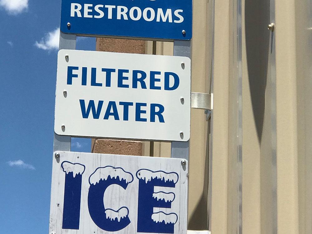 Signs indicating restrooms, filtered water and ice at NOMADLAND RV STAY