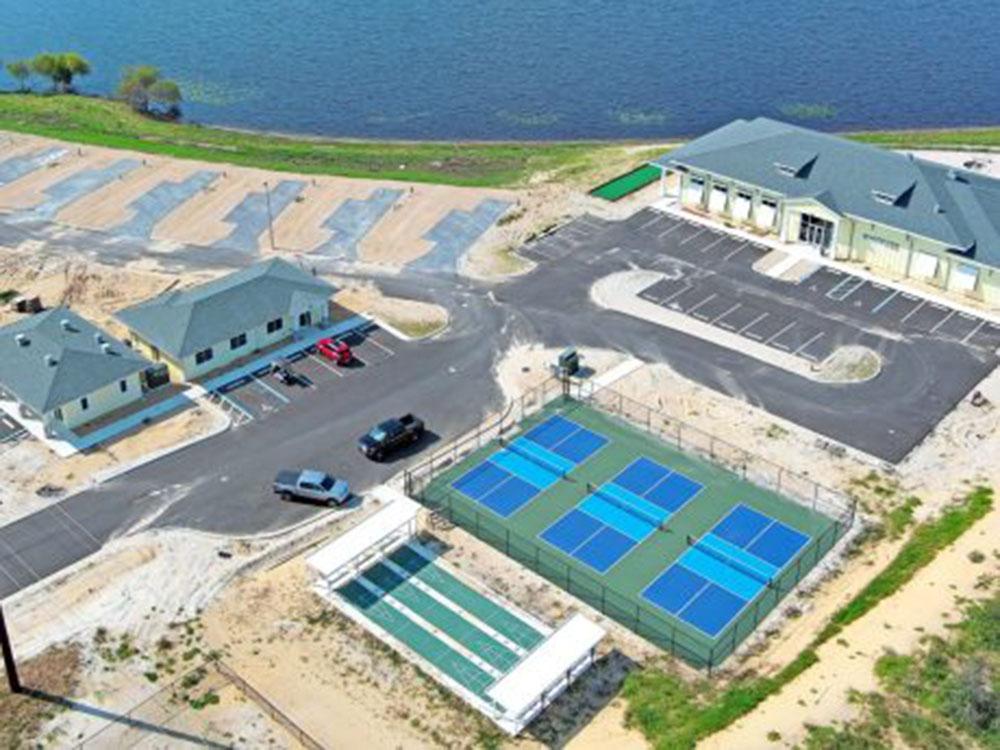 Aerial view of buildings construction, tennis courts and shuffleboard at WATERSIDE RV RESORT