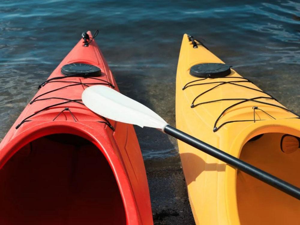 An orange and yellow kayak in the river at RIVER MEADOW CAMPGROUND