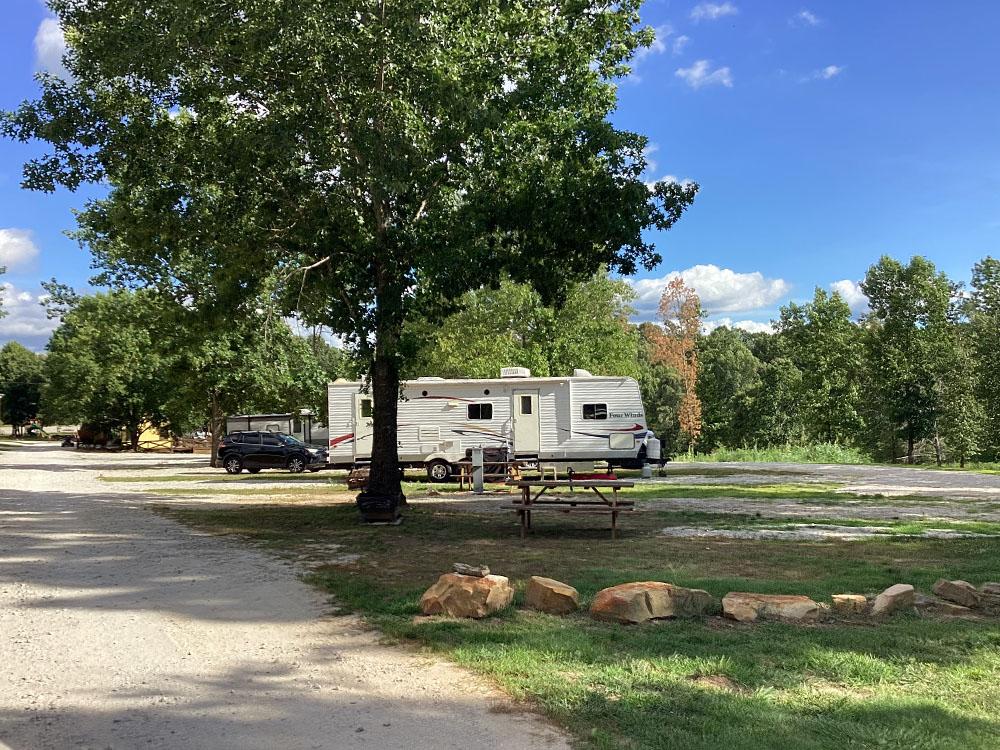 Travel trailer under a tree at JESSIE JAMES JUNCTION RV PARK