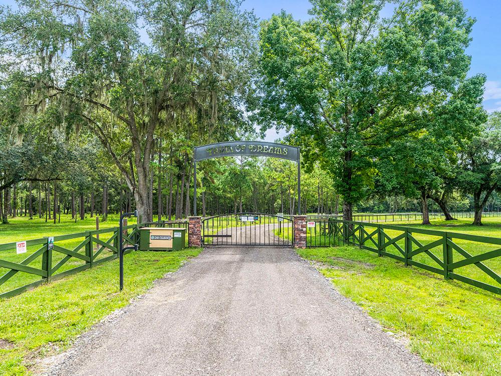 A gated grand entrance with arched sign at FARM OF DREAMS RESORT