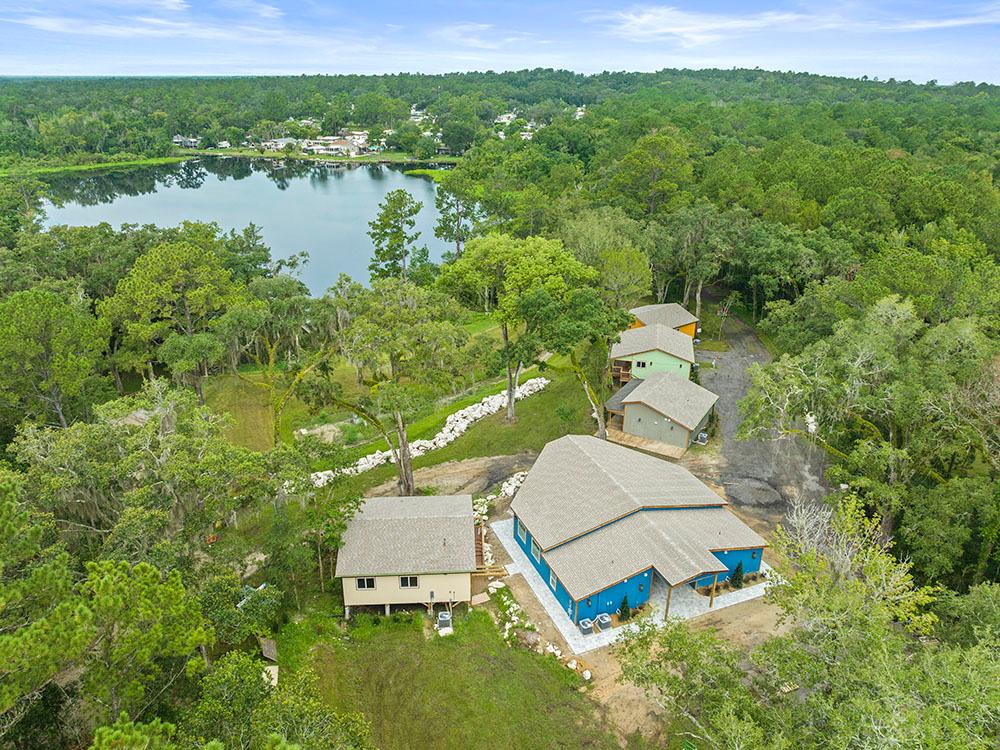 Aerial view of the property with buildings and lake at FARM OF DREAMS RESORT