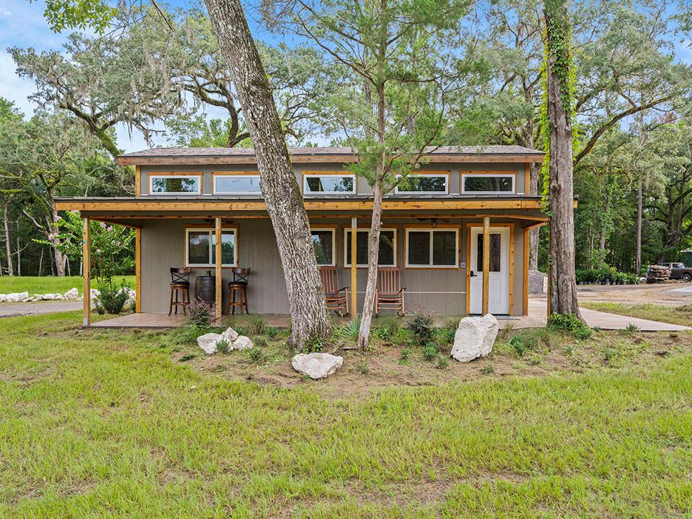 Exterior of a rental cabin with a porch at FARM OF DREAMS RESORT