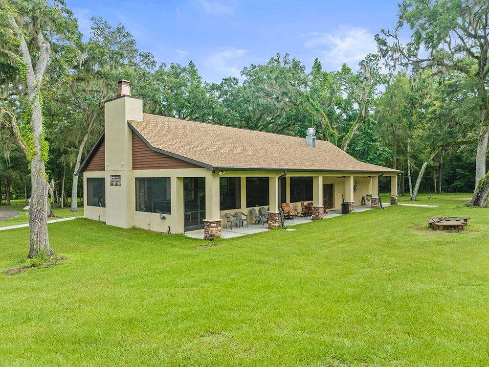 Exterior of the rec hall with lush lawn and trees at FARM OF DREAMS RESORT