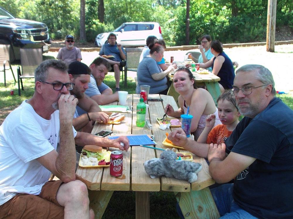 People eating at a picnic table at PINE RIDGE RV PARK