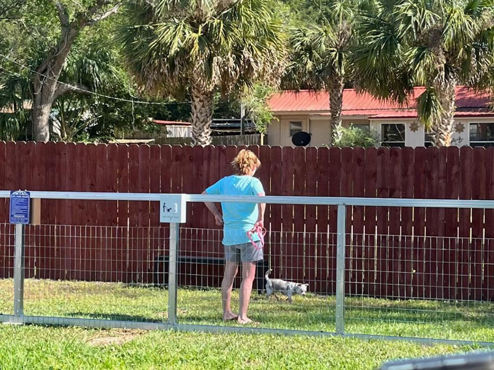 Person watching their dog in the enclosed dog run at STEINHATCHEE VILLAGE RV PARK