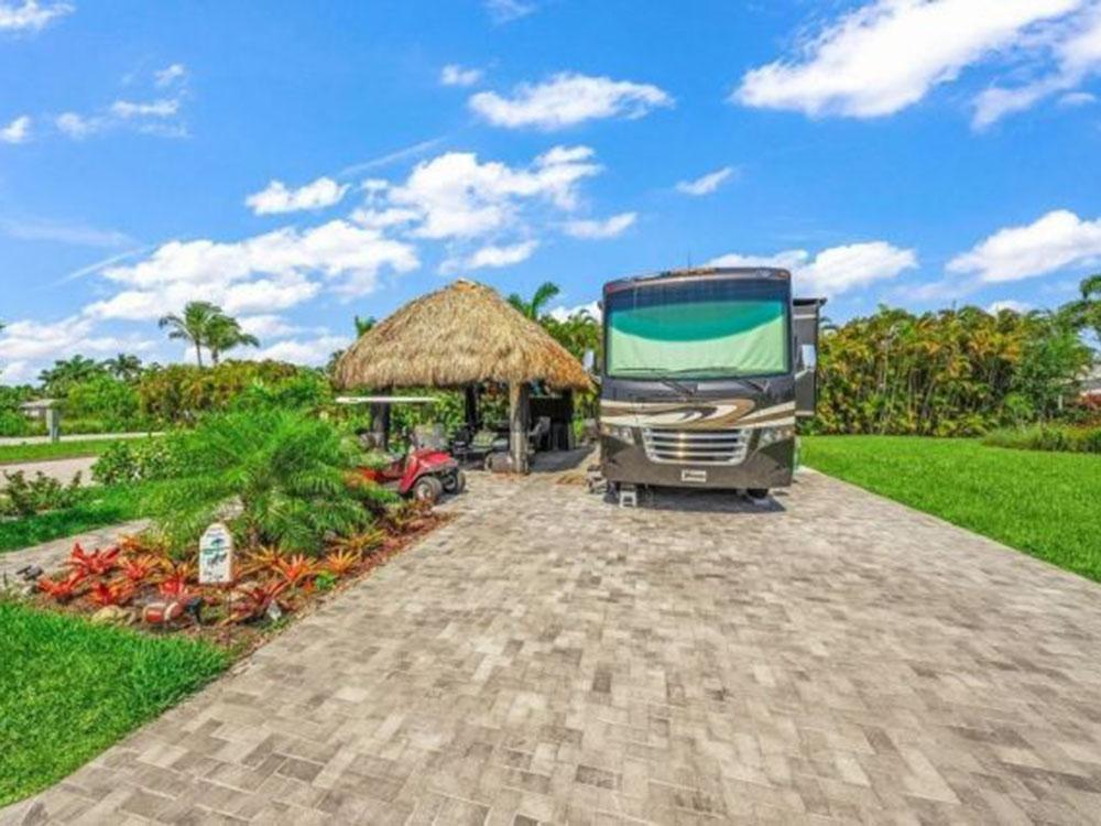 RV parked in lot with thatched canopy at LAGUNA CARIBE