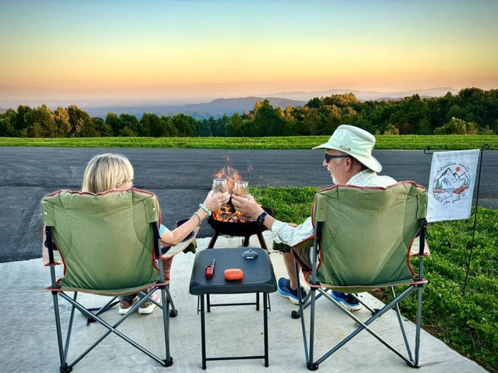 Couple in chairs at sunset at The Oaks RV Resort