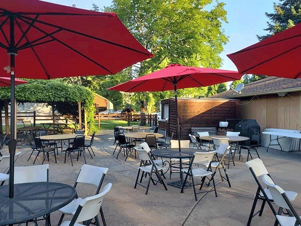 Tables with red umbrellas at APPLEGATE RV RESORT