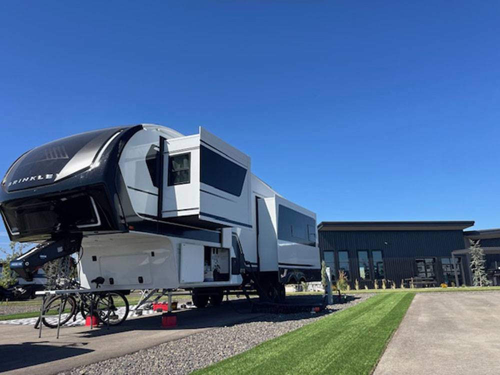 Large fifth-wheel in a paved site at Sun Creek Point RV Park