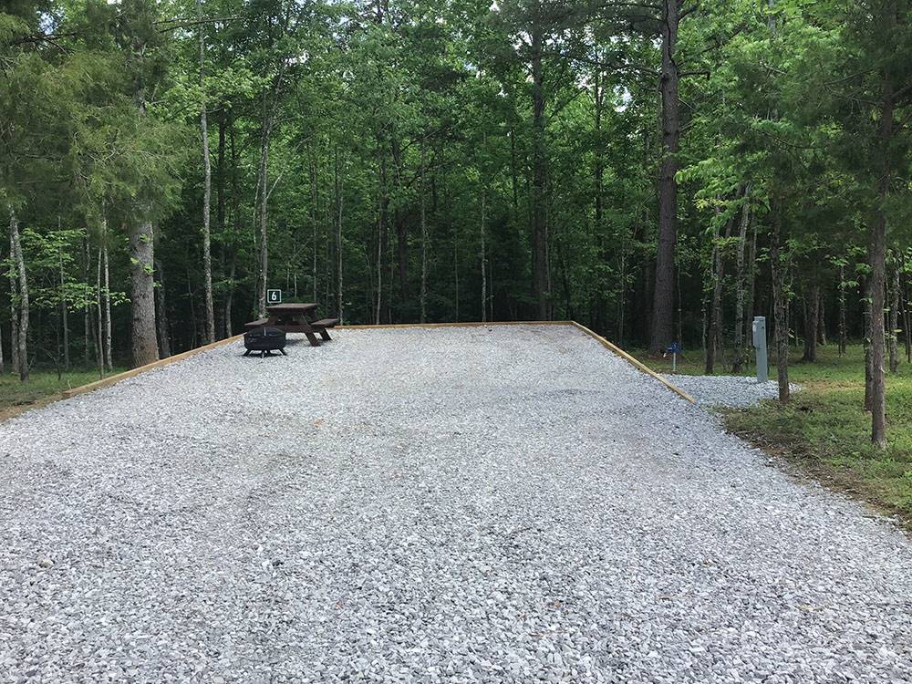 A gravel site with table and grill