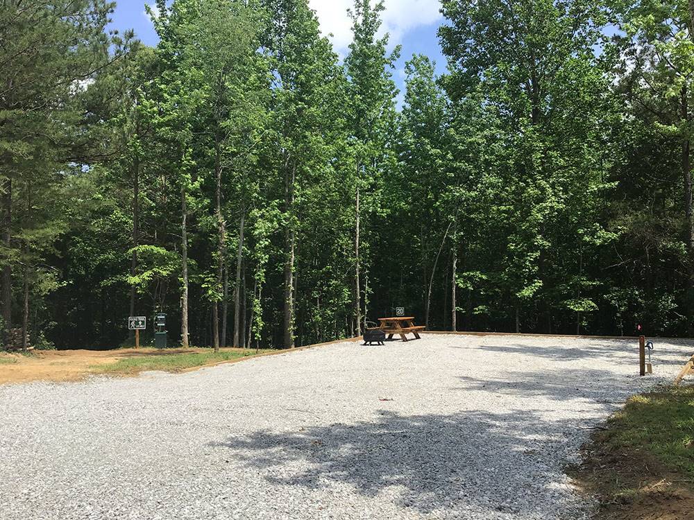 A gravel site surrounded by tall trees