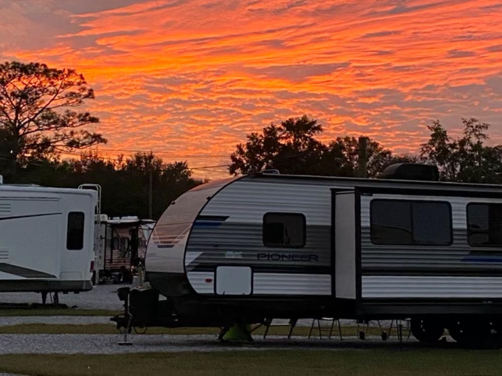 RVs against an orange sunset at PALM COVE RV VILLAGE