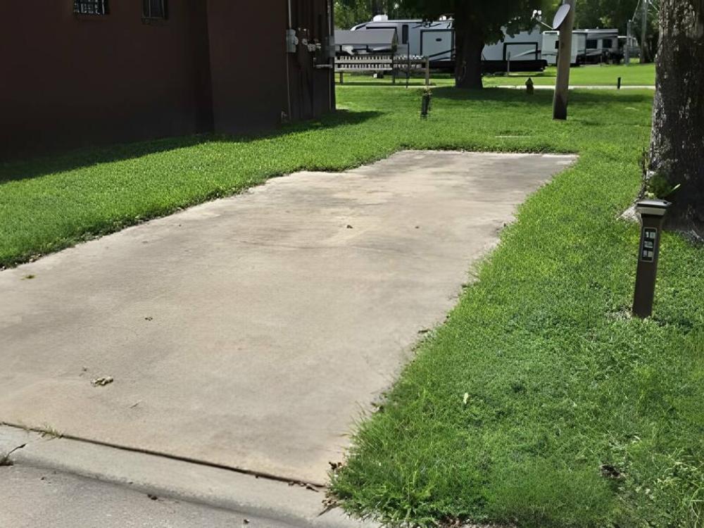 Paved site surrounded by grass at Birch Creek RV Park