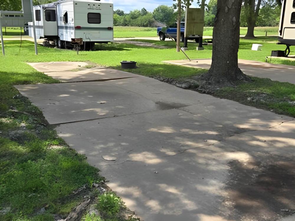 Open RV space near parked trailer at Birch Creek RV Park