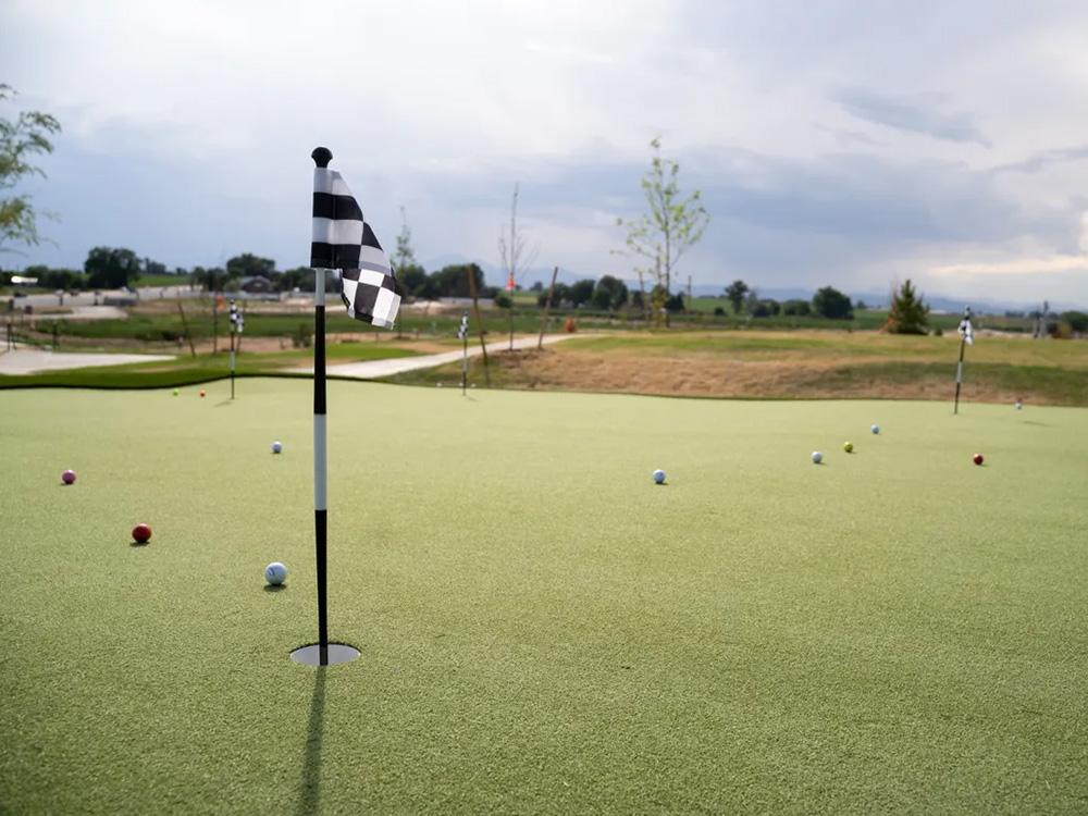 Putting green with flag and golf balls at GOPHER GULCH RV & CAMPGROUND