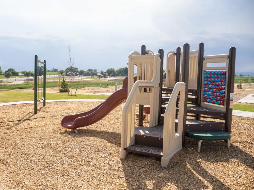 Children's playground with swings and slide at GOPHER GULCH RV & CAMPGROUND