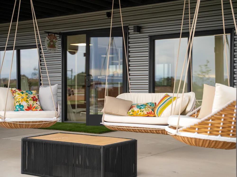 Porch of building with hanging chairs at GOPHER GULCH RV & CAMPGROUND