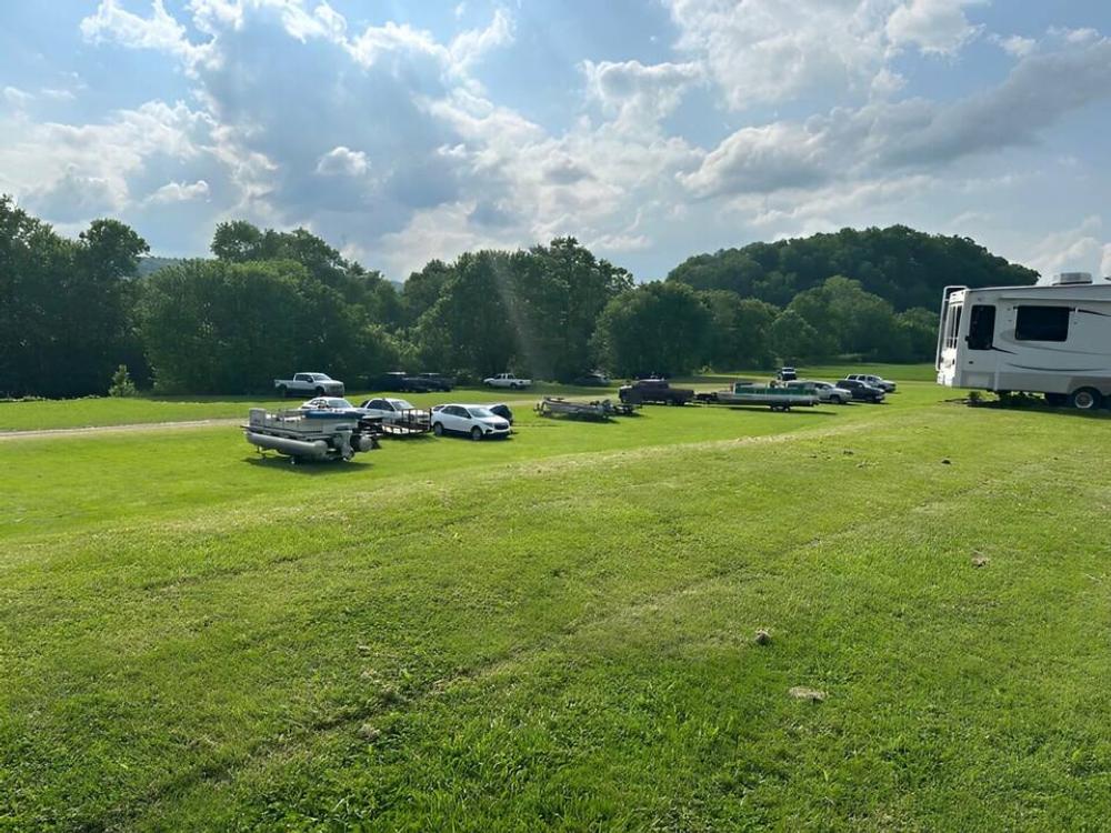 Vehicles parked on a grassy area at Still Waters Campground