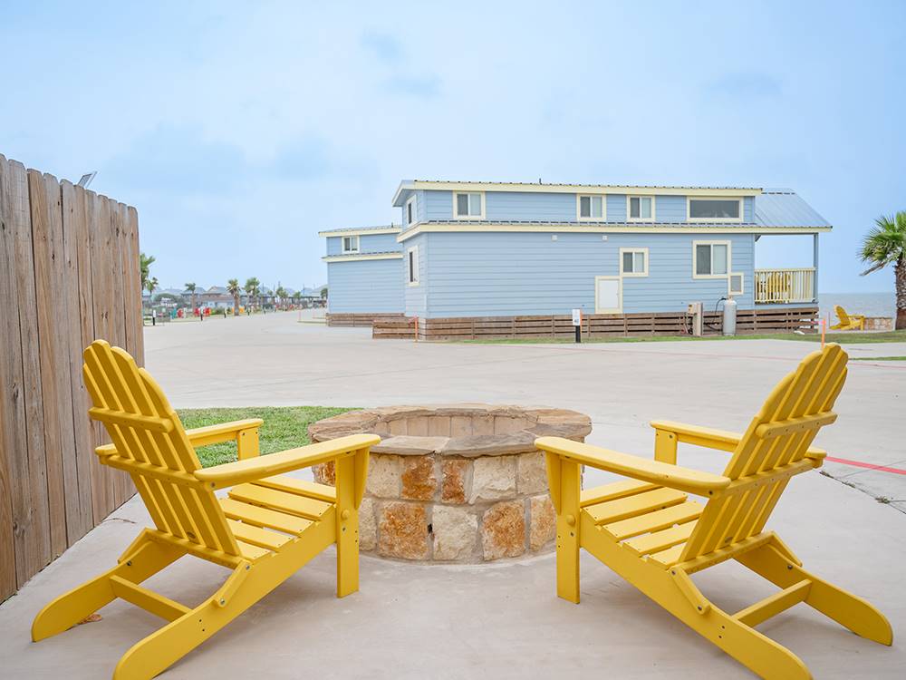 Two yellow chairs around a fire pit at Firefly Resort Coastal Bend