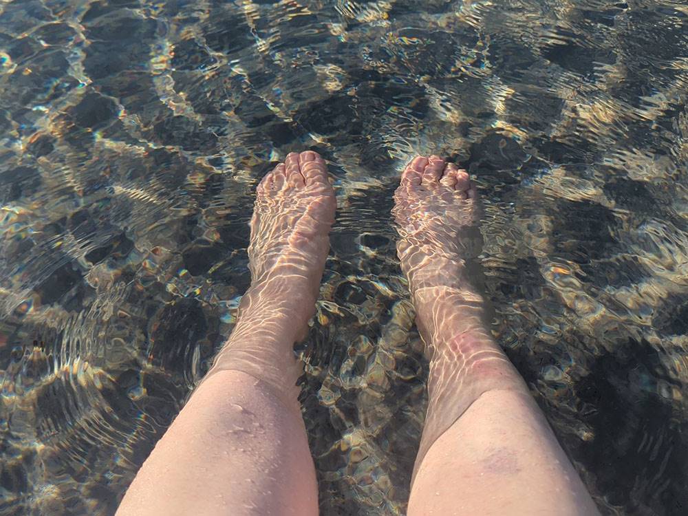 Feet and legs in the water at Lagoon Ranch RV Resort