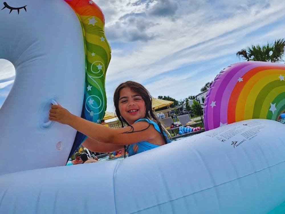 A young girl on a floaty in the pool at LHTX RV Resort