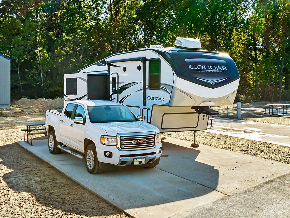 Truck and fifth wheel parked at a paved site at Blue Springs RV Park