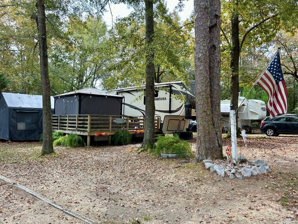 Shady RV site with deck and enclosed canopy at Mill Creek Marina & Campground