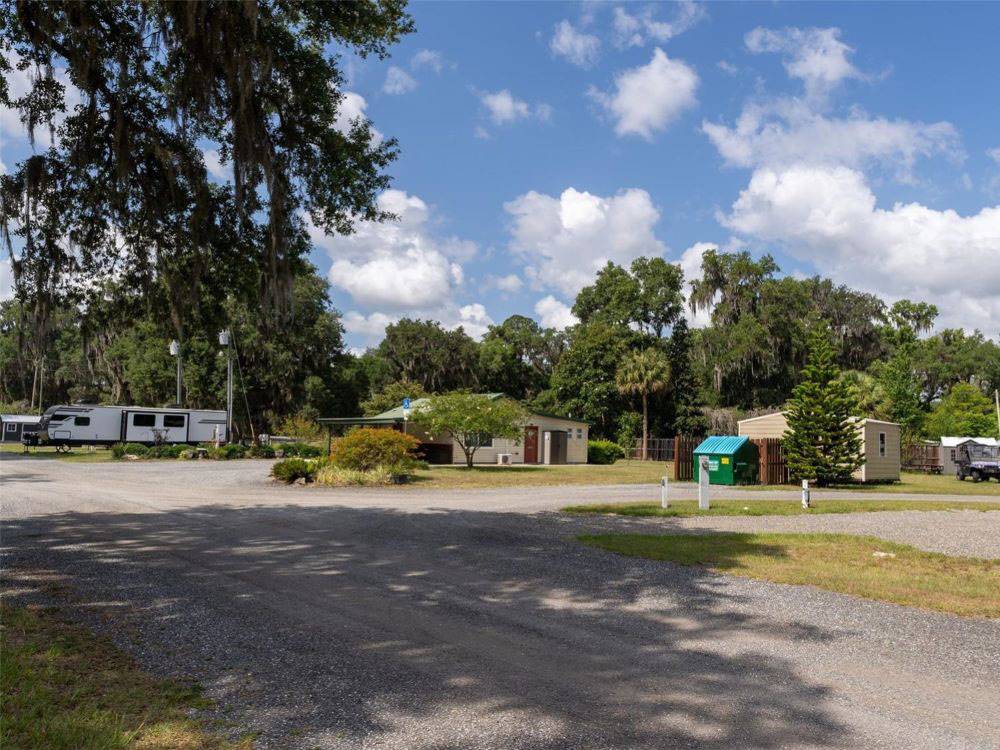 A gravel road leading to buildings and RV sites at Old Florida RV Resort