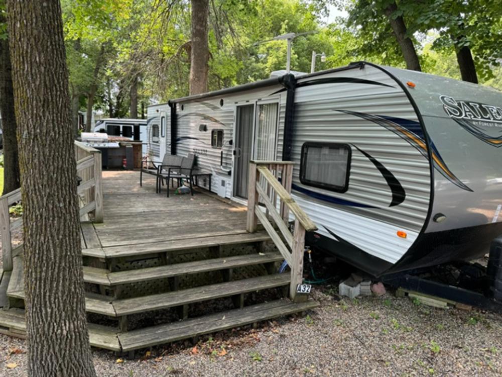 Travel trailer parked at a site with a porch at Big Foot Resort