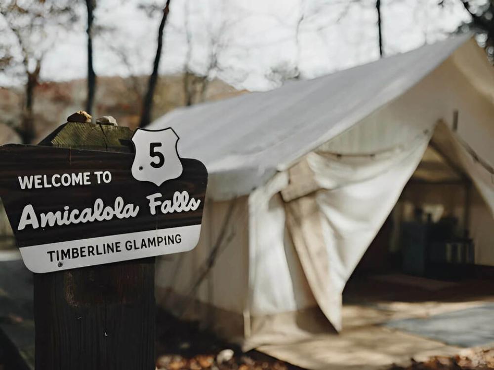 The park sign near a safari tent at Timberline Glamping at Amicalola Falls