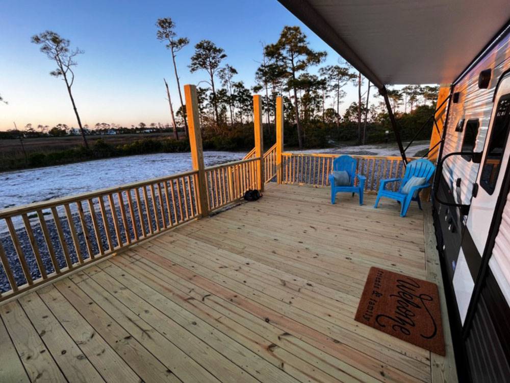 A wooden deck next to a parked RV