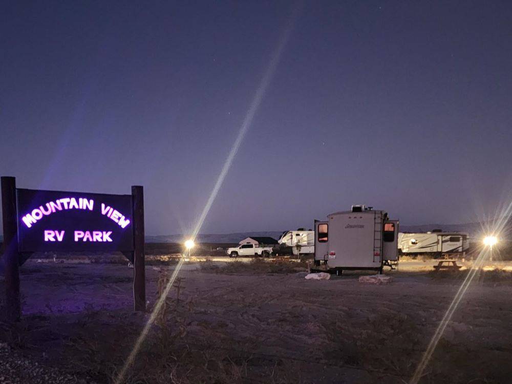 The neon lighted park sign at night at Mountain View RV Park