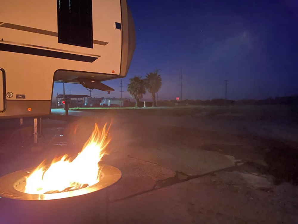 A fire ring near an RV at site at Holly Beach RV Park