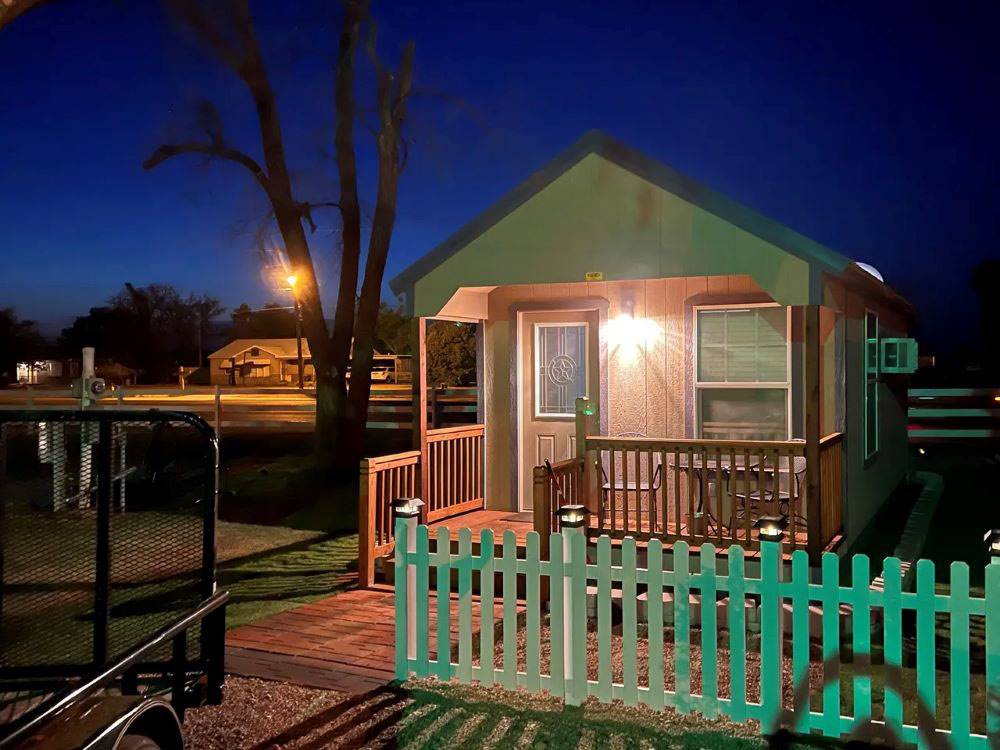 A little cabin with a front porch, in the evening
