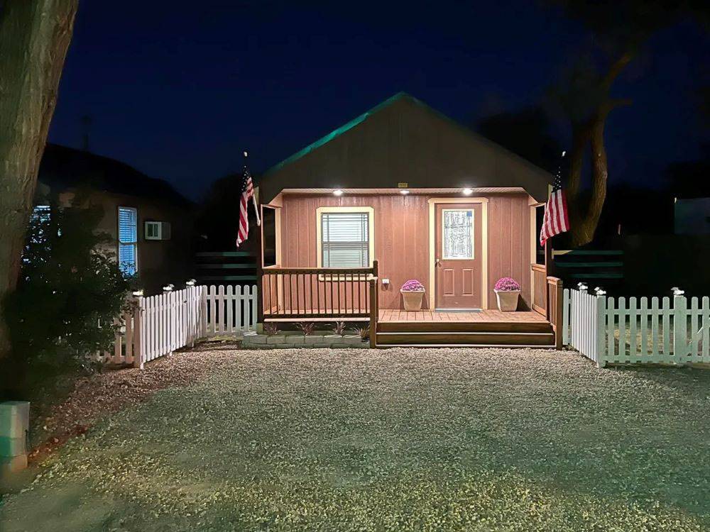 A cabin with a USA flag on the porch