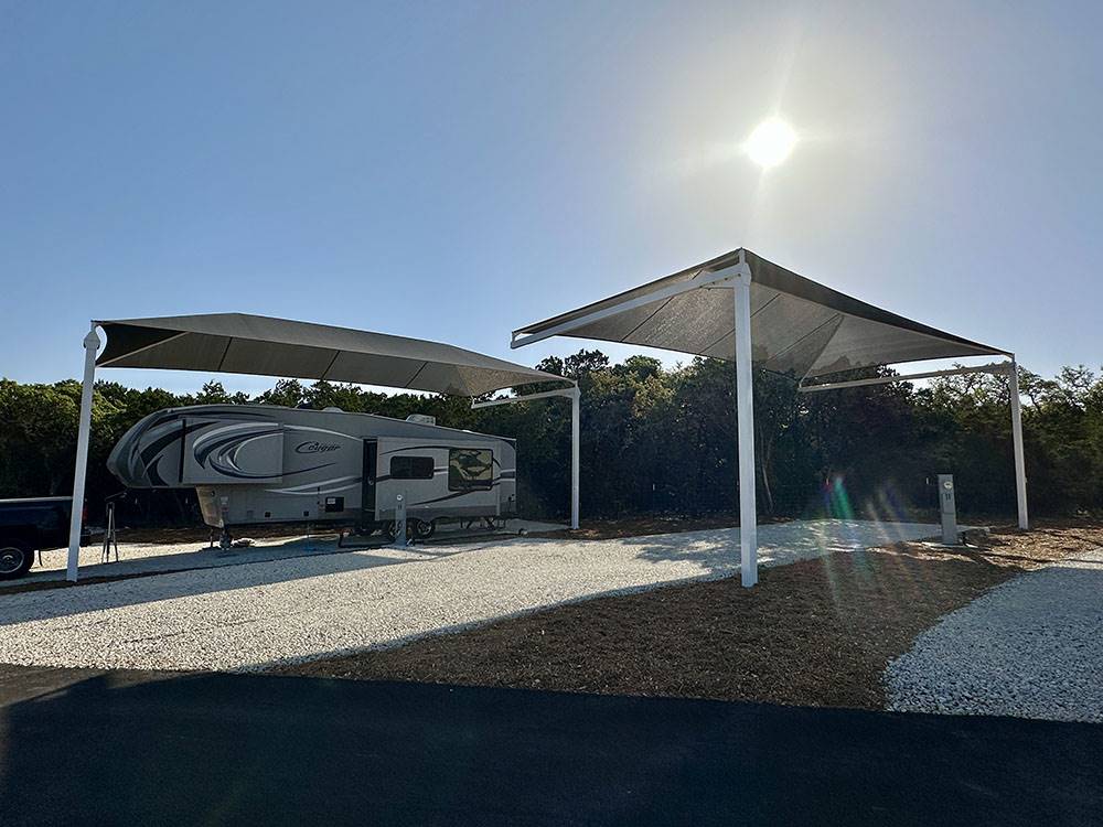 A travel trailer under an awning at site