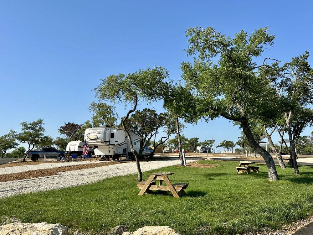 Picnic tables on a grassy patch near an RV site